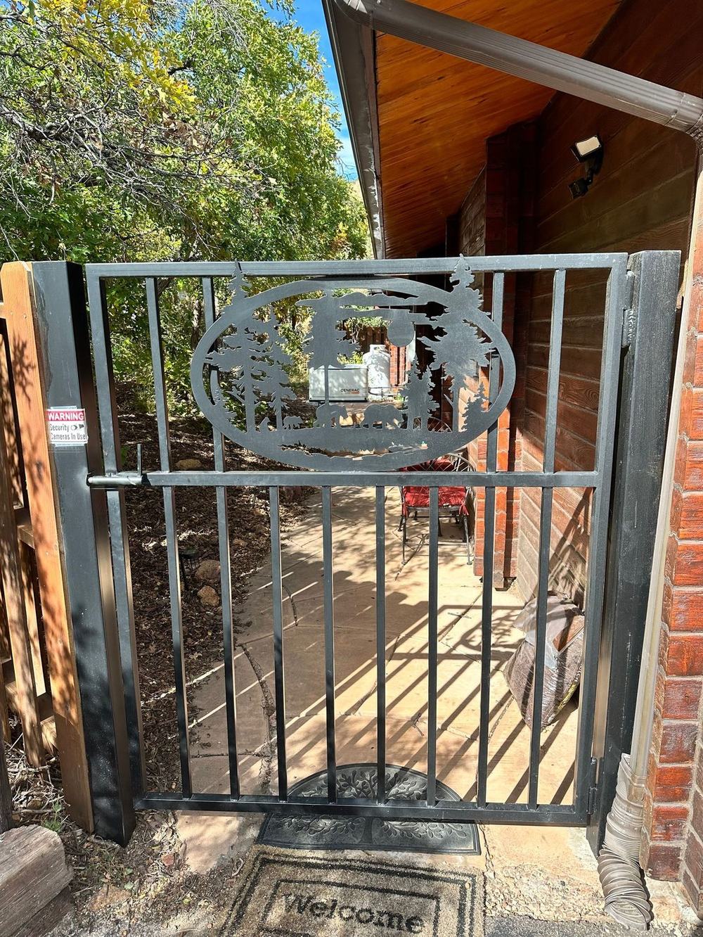 Custom fabricated ornamental iron gate with a hand-cut nature medallion